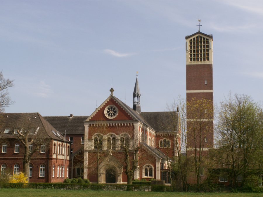 Bâtiments en briques rouges d’un ensemble monastique avec église et clocher