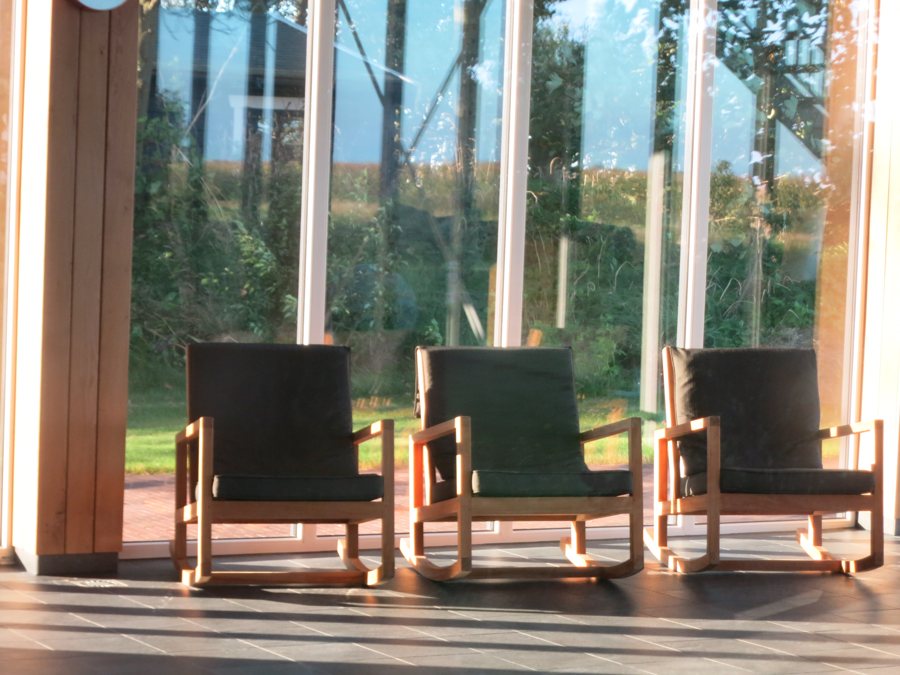 Espace détente d’un hôtel de luxe avec des fauteuils près de grandes baies vitrées
