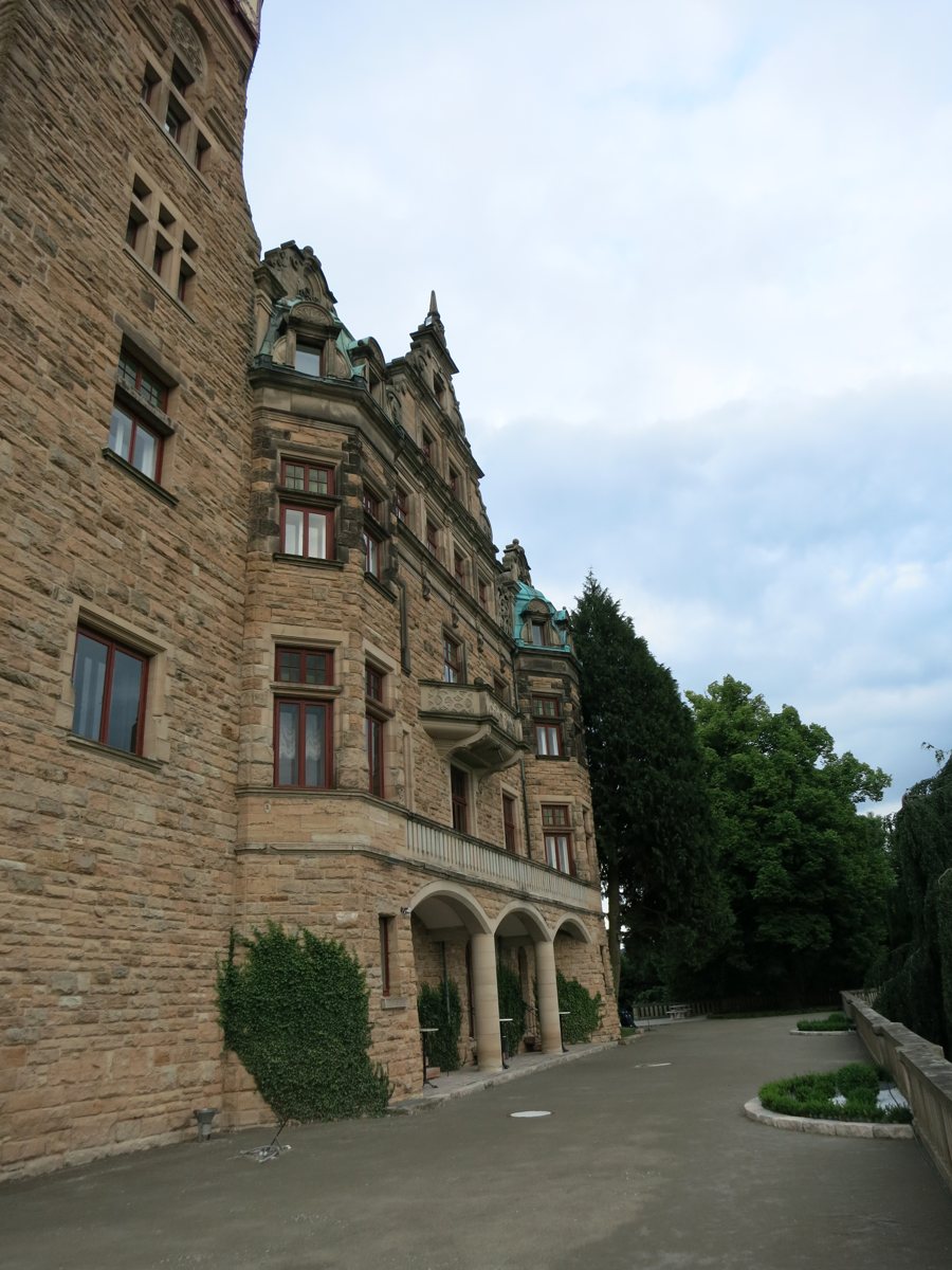 Façade en pierre d’un hôtel-château avec entrée en arcades