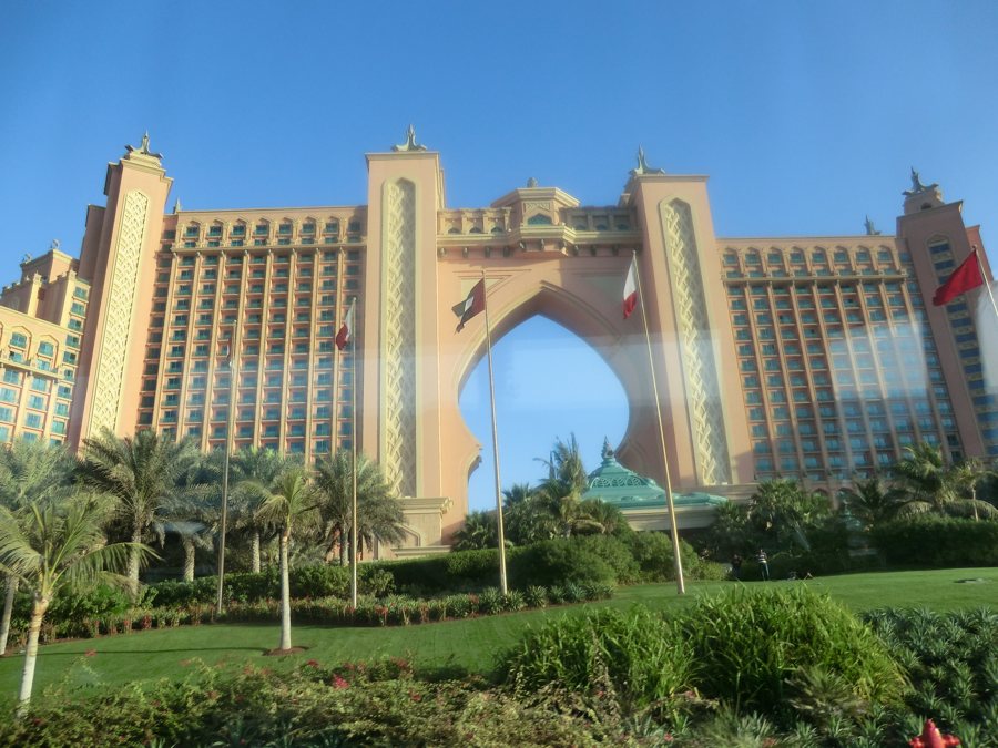 Hôtel à Dubaï avec une grande arche et un jardin de palmiers