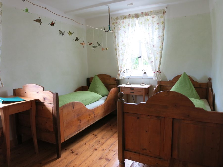 Chambre d’hôtel avec deux lits en bois et un bureau