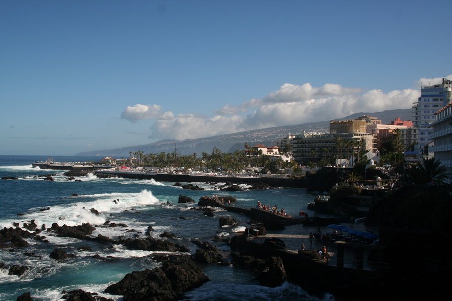 Hôtels sur une côte rocheuse avec vagues et promenade
